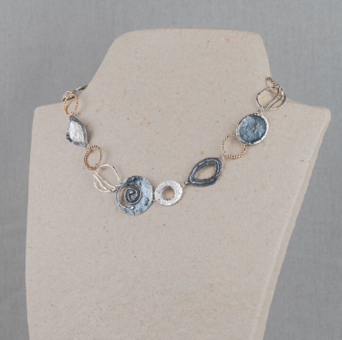 Collier uit de Touch of Gold-collectie van Jéh Jewels, gemaakt van 925 sterling zilver met hoogglans, geoxideerd zilver en een laagj Gold Filled. Dit collier bestaat uit verschillende organische vormen, wisselend van materiaal. Dit collier doet ons denken aan een dagje relaxen op het strand, stylish en bohemian.